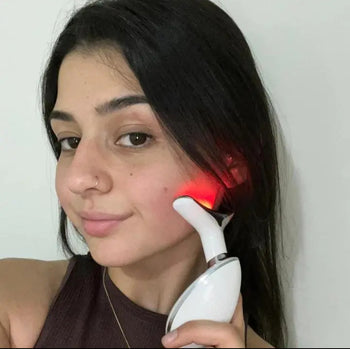 Woman holding a facial beauty massager near her cheek