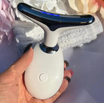White facial beauty massager held in a hand